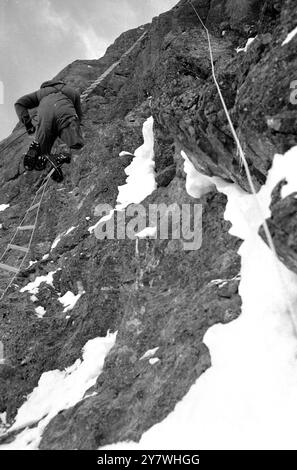 Kleine Scheidigg , Suisse : Britannique et quatre Allemands après l'ascension historique du mur nord tueur de l'Eiger . Guenther Strobel un membre de l'équipe allemande gravissant la route 'Direct' invaincue de la face Nord de l'Eigar . 6 mars 1966 Banque D'Images