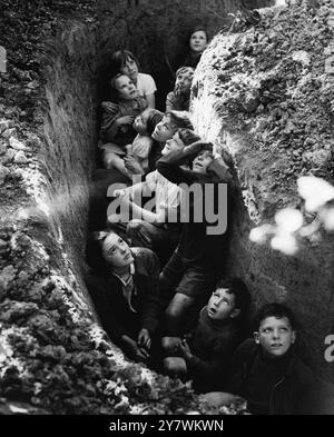 Les enfants des cueilleurs de houblons s'abritent pour assister à la bataille d'Angleterre qui fait rage au-dessus de leur tête. Prise par John Topham 'l'image la plus humaine de l'année' selon World Press News 1940, cette image est devenue l'une des images les plus publiées de la guerre - 1940. Publié en pleine page dans Life Magazine, 1940. Pendant les années de guerre, il a été utilisé par le ministère de l'information, et par des annonceurs, ainsi que par des artistes New-yorkais qui en ont fait la base de croquis et de peintures pour des expositions de guerre (World Press News, 1940). Banque D'Images