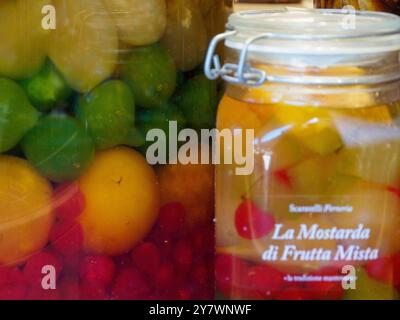 Mantoue, Italie 30 septembre 2024 les bocaux en verre remplis de fruits colorés conservés dans du sirop, exposés sur un étal de marché à mantoue, attirent les touristes v Banque D'Images
