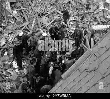 Les sauveteurs retirent un survivant de sa maison endommagée par la bombe après un raid aérien ennemi pendant la seconde Guerre mondiale Banque D'Images