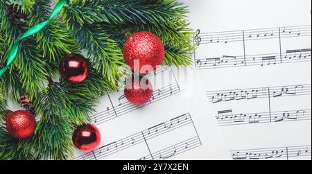 Décorations de Noël sur les feuilles de notes de musique, vue de dessus Banque D'Images