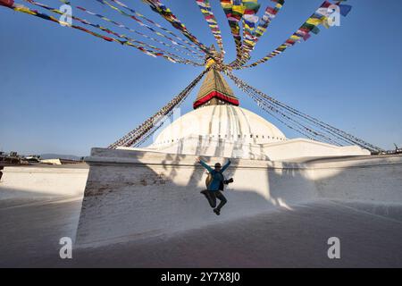 Raquel pratique son saut vertical au Stupa Boudhanath à Katmandou, au Népal. Banque D'Images