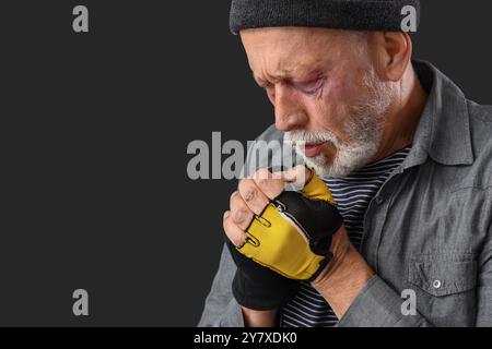 Homme sans-abri gelé sur fond sombre, gros plan Banque D'Images