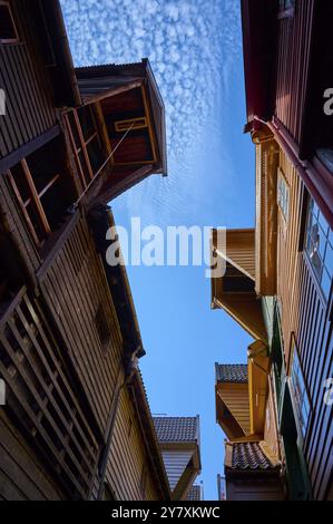 Ruelle étroite entre de vieilles maisons à colombages avec escaliers, dominant l'architecture en bois dans les tons rouge et brun, entrepôts historiques, Bryggen, Bergen Banque D'Images