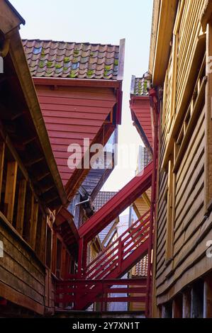 Ruelle étroite entre de vieilles maisons à colombages avec escaliers, dominant l'architecture en bois dans les tons rouge et brun, entrepôts historiques, Bryggen, Bergen Banque D'Images