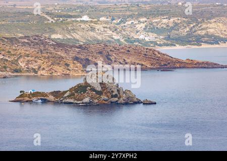 Bateau d'excursion ancré près de l'île de Kastri avec la chapelle d'Agios Nikolaos dans la baie de Kefalos sur l'île de Kos en Grèce Banque D'Images