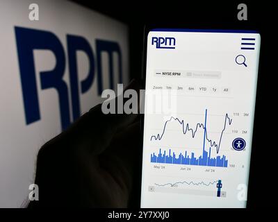 Dans cette illustration photo, une personne tient un téléphone portable avec le site Web de la société américaine de revêtements RPM International Inc devant le logo de l'entreprise. Banque D'Images