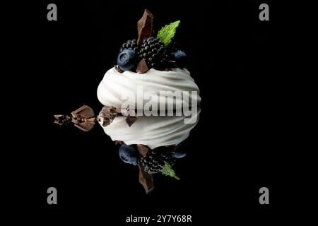 Mini pavlova avec des myrtilles, des mûres et des pépites de chocolat Banque D'Images