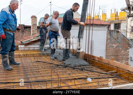 Belgrade, Serbie-10 juin 2023 : les ouvriers de la construction coulent du béton sur les barres d'armature à l'aide d'une pompe à béton. Bétonnage d'une plaque de construction avec du béton prêt à l'emploi Banque D'Images