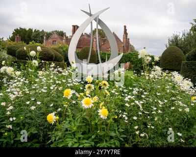 Manoir Chenies en septembre ; Dahlia 'Freya's Paso Doble', Marguerites blanches, dahlias blanches dans le jardin topiaire avec encadrement sculpté courbé. Banque D'Images