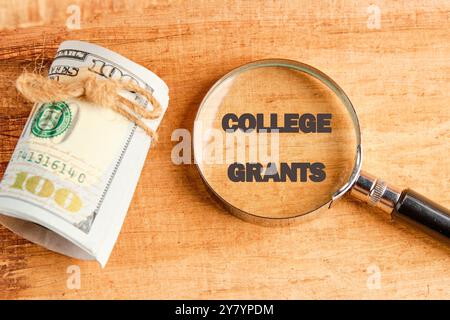 Concept DES SUBVENTIONS d'entreprise et D'UNIVERSITÉ. Copier l'espace. Grant Symbol COLLEGE OCTROIE par une loupe sur le papyrus à côté des billets d'un dollar Banque D'Images