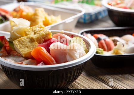 Une vue de plusieurs bols et assiettes de sushi morceaux. Banque D'Images