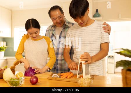 Préparer des légumes, cuisiner en famille multiraciale ensemble dans la cuisine, profiter du temps de qualité Banque D'Images