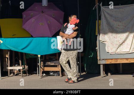 Une femme porte un enfant dans la rue avec kiosque, Bangkok, Thaïlande Banque D'Images