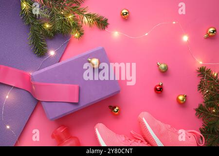 Composition plate de pose avec tapis de yoga et décor de Noël sur fond rose Banque D'Images