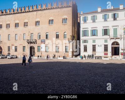 Mantoue, Italie 30 septembre 2024 touristes appréciant une journée ensoleillée de marche sur la piazza sordello, la place principale de mantoue, avec le palais ducal dans le backgro Banque D'Images