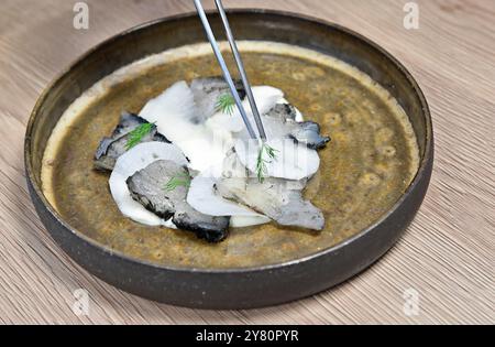 Plat, spécialité nordique : gravlax de morue avec encre de seiche Banque D'Images