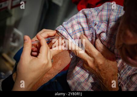 Vaccination en pharmacie : un pharmacien vaccine une personne âgée contre la grippe et le covid19. Vaccin contre la grippe, grippe saisonnière Banque D'Images