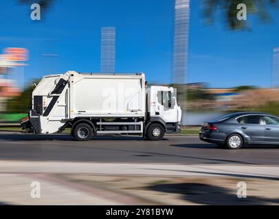 camion à ordures en mouvement sur un fond flou par une journée ensoleillée Banque D'Images