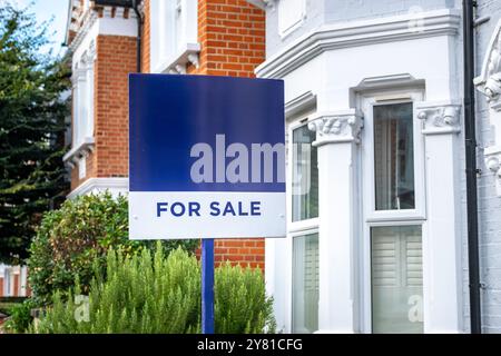 Agent immobilier signe 'a vendre' sur la rue des maisons mitoyennes britanniques Banque D'Images