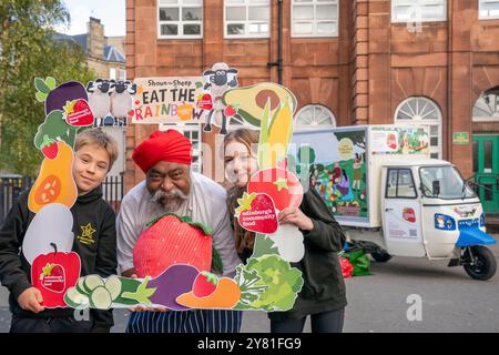 Les élèves Antonio Marin-Kalisz, 10 ans (à gauche) et Zofia Krolikwska, 11 ans (à droite) de l'école primaire St Mary's de Leith avec le célèbre chef local Tony Singh lors du dévoilement du nouveau tuk-tuk éducatif de Edinburgh Community Food. Le tuk-tuk servira d’initiative éducative mobile pour enseigner aux communautés la nutrition en rendant la cuisine saine amusante et accessible, et en la plaçant au cœur de la communauté. Date de la photo : mercredi 2 octobre 2024. Banque D'Images