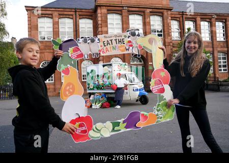 Les élèves Antonio Marin-Kalisz, 10 ans (à gauche) et Zofia Krolikwska, 11 ans (à droite) de l'école primaire St Mary's de Leith avec le célèbre chef local Tony Singh lors du dévoilement du nouveau tuk-tuk éducatif de Edinburgh Community Food. Le tuk-tuk servira d’initiative éducative mobile pour enseigner aux communautés la nutrition en rendant la cuisine saine amusante et accessible, et en la plaçant au cœur de la communauté. Date de la photo : mercredi 2 octobre 2024. Banque D'Images