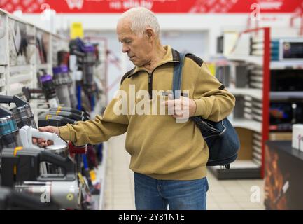 Senor homme retraité achetant aspirateur droit dans la salle d'exposition du magasin d'appareils électriques Banque D'Images