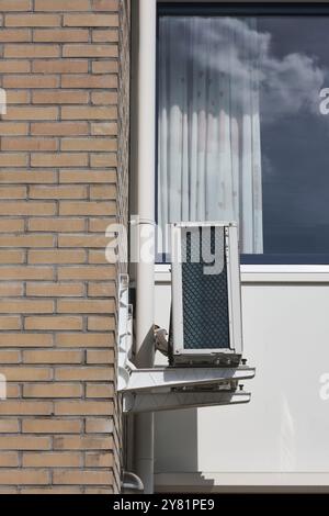 unité de pompe à chaleur à source d'air moderne montée sur le mur extérieur d'une maison, démontrant une technologie économe en énergie pour le chauffage et le refroidissement dans un susta Banque D'Images