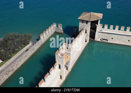 Bassin portuaire du château avec des remparts plats de Guelph, château de Scaliger, Castello Scaligero, à Sirmione, château à douves sur la rive sud du lac Banque D'Images