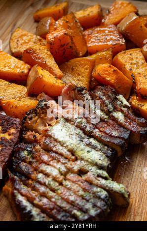 Fait maison, rôti au four et assaisonné citrouille à côté de tranches de steak avec beurre fondant. Gros plan, vue de dessus, personne. Banque D'Images