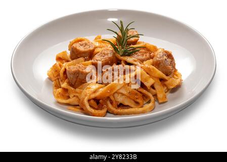 Tagliatelle pâtes aux œufs avec sauce tomate rouge avec morceaux de saucisse et brin de romarin dans une assiette blanche isolée sur blanc Banque D'Images