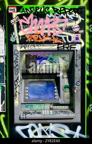 Un guichet automatique de caisse qui fonctionne semble négligé devant un magasin à Brick Lane, Londres. Banque D'Images