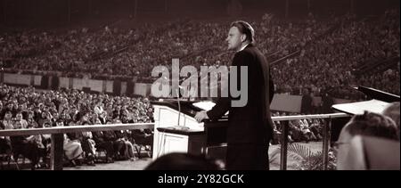 L'évangéliste américain Billy Graham s'adressant à une foule au stade Doak Campbell de l'Université d'État de Floride à Tallahassee, Floride, le 11 février 1961. (ÉTATS-UNIS) Banque D'Images