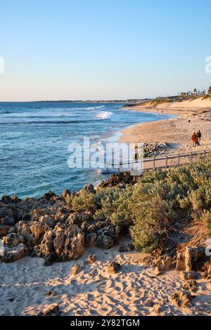 Une image verticale de Mettam's Pool près du coucher du soleil avec des roches calcaires et de la végétation côtière au premier plan, Perth, Australie occidentale. Banque D'Images