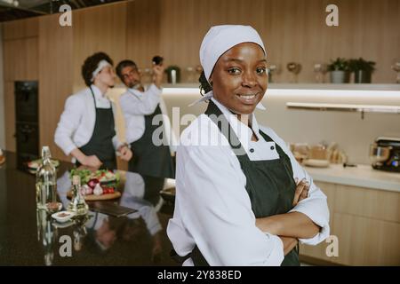Portrait de sourire heureux et beau cuisinier féminin à la cuisine du célèbre restaurant Banque D'Images