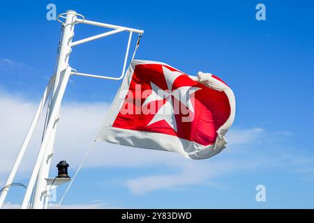 Drapeau maltais sur la poupe d'un navire de croisière sur fond de ciel bleu Banque D'Images