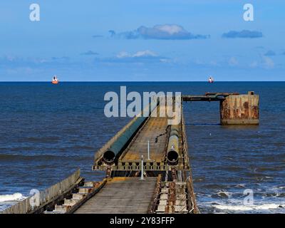 Regardant sur le quai Steetly alors que deux navires jettent l'ancre au large de la côte près de Hartlepool. La jetée est une relique de l'industrie chimique locale. Banque D'Images