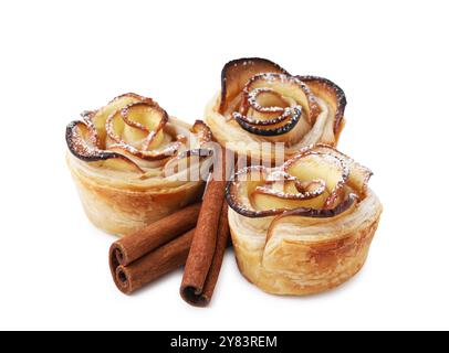 Roses de pomme fraîchement cuites et bâtonnets de cannelle isolés sur blanc. Pâte feuilletée Banque D'Images