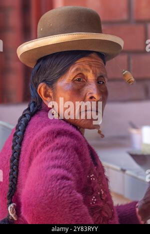 Femme autochtone locale portant un chapeau melon et des cheveux tressés traditionnels, Pisac, Pérou Banque D'Images