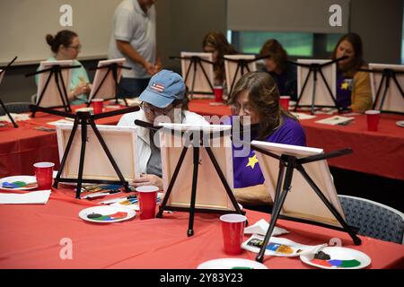 Kingwood, Virginie occidentale, États-Unis. 28 septembre 2024. (De gauche à droite) amie Gullifer et Sue VanGiesen peignent leurs toiles lors d'un cours de peinture tenu pendant la retraite annuelle des familles Gold Star de la Garde nationale de Virginie-occidentale le 28 septembre 2024 au Camp Dawson, à Kingwood, en Virginie-occidentale. Depuis sa première désignation par le Congrès en 1936, le dernier dimanche de septembre a été reconnu comme la Fête des mères étoile d'or et en 2012 a été déclaré âGold Fête des mères étoiles et des familles. La Garde nationale de Virginie-occidentale accueille des familles Gold Star de Virginie-occidentale et de Pennsylvanie qui se réunissent chaque année au C. Banque D'Images