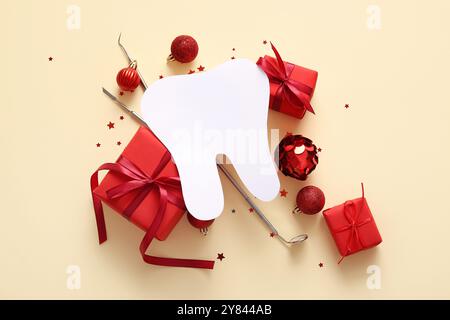 Composition avec dent en papier, outils de dentiste, cadeaux de Noël et décorations sur fond de couleur Banque D'Images