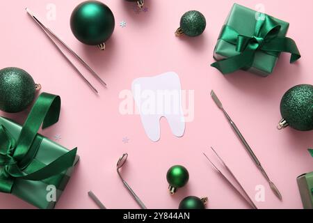 Composition avec dent en papier, outils de dentiste, cadeaux de Noël et décorations sur fond rose Banque D'Images