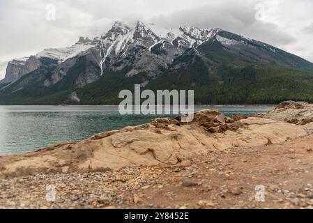 Incroyables vues sur la nature au lac Minnewanka dans le monde entier célèbre Alberta au printemps avec des montagnes enneigées en arrière-plan au-dessus du lac aquatique ci-dessous. Banque D'Images