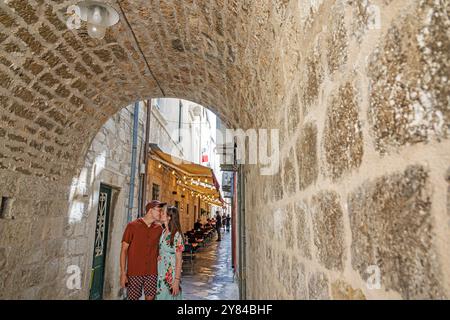 Dubrovnik Croatie, vieille ville, arche médiévale des murs de la ville, visiteurs homme femme couple embrassant moment romantique, à l'intérieur du tunnel intérieur, pavé de calcaire pe étroit Banque D'Images