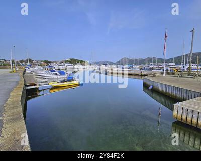 Un port tranquille avec des bateaux sur une jetée, entouré de montagnes sous un ciel bleu, Sandnes, Fylke Rogaland, Norvège, Europe Banque D'Images