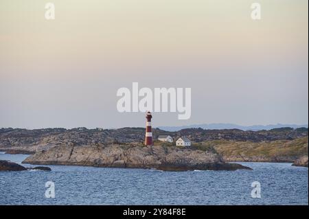 Phare et deux maisons sur la côte rocheuse, avec une atmosphère de mer calme en arrière-plan, Vestland, Norvège, Europe Banque D'Images