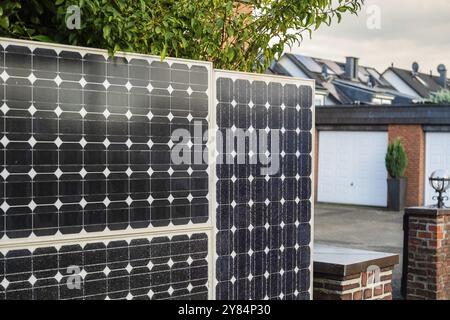 Clôture solaire, panneaux solaires comme clôture de jardin et écran d'intimité dans une rue à Langenfeld, Allemagne, Europe Banque D'Images
