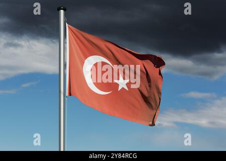 Drapeau turc devant un ciel sombre Banque D'Images