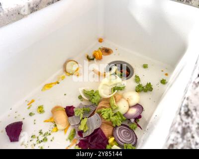 Déchets de légumes dans un évier prêts à être jetés après la préparation du repas Banque D'Images