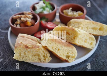 Un savoureux plateau de petit déjeuner avec du pain fraîchement cuit et assortiment d'accompagnements à déguster Banque D'Images